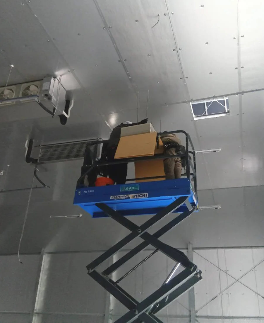 高所作業車で空調設備を施工する温建スタッフ